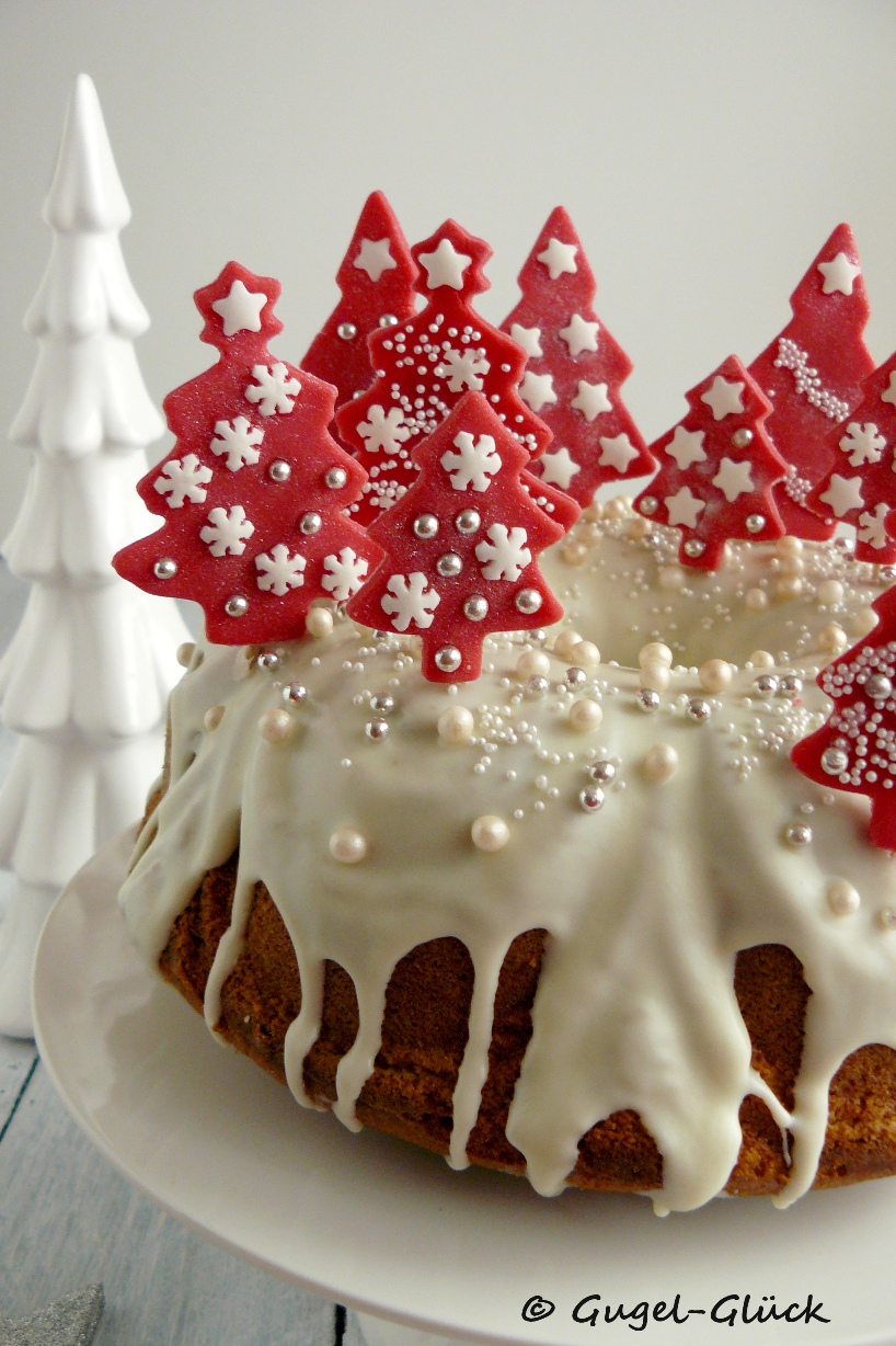 Eierlikör-Gugelhupf mit Pflaumenmus-Swirl und Schokoladenguss und Dekoration aus roten Fondant-Tannenbäumchen