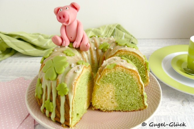 Pistazien-Orangen-Marmorgugelhupf mit Glücksklee aus Fondant und einem Schweinchen aus Modellierschokolade